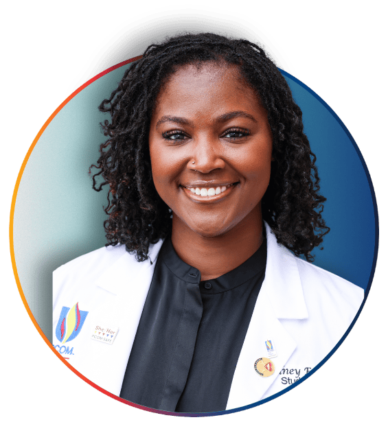 PCOM student with curly hair smiling in a white coat and black top, framed in a circular graphic with red and blue accents