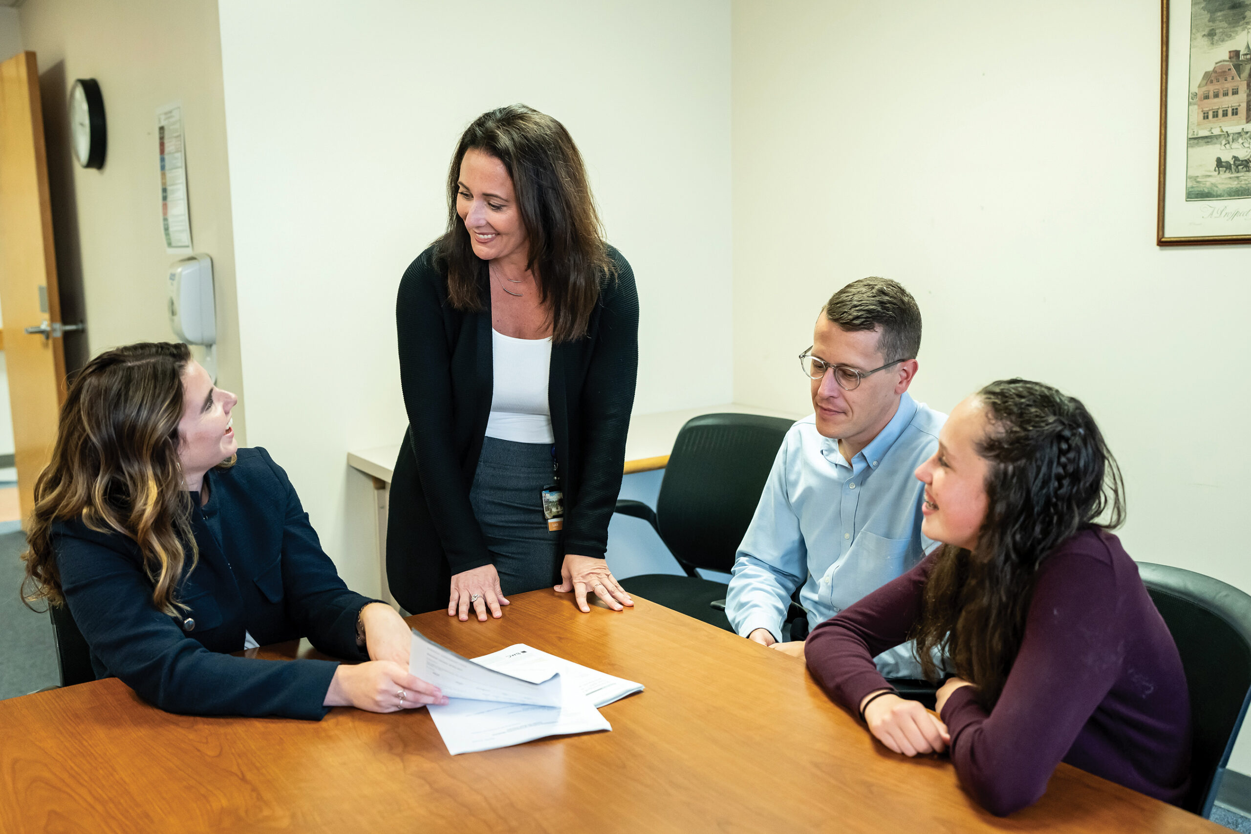 school psychology students and faculty gathering around a table for a meeting